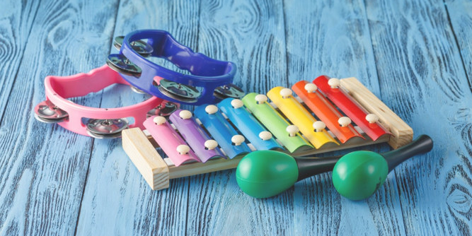 Percussion instrumenter i fine farver. To tamburiner, en zylofon og to maracas